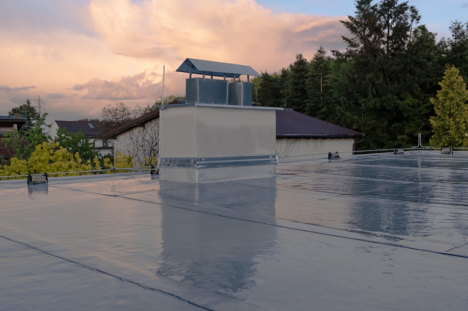 stock-photo-flat-roof-covered-with-bitumen-membrane-and-silver-lacquer-with-chimney-on-a-private-house-1998513722-transformed